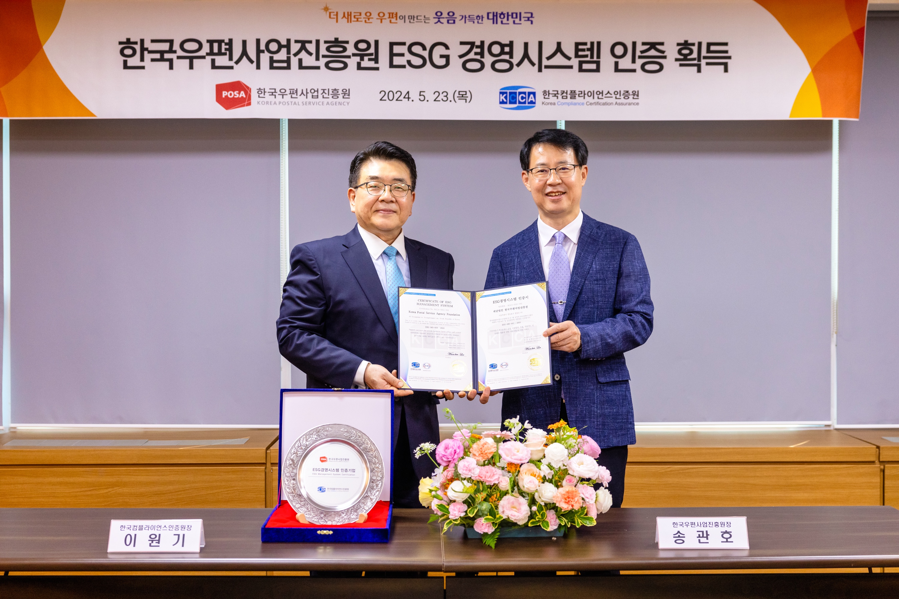 한국우편사업진흥원 ESG 경영시스템 인증서를 들고 있는 사진