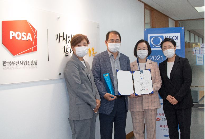 한국우편사업진흥원 우편고객센터, 2021년 KSQI 택배부문 3년 연속, 통산 10회 우수콜센터로 선정되어 사진을 찍고있는 모습