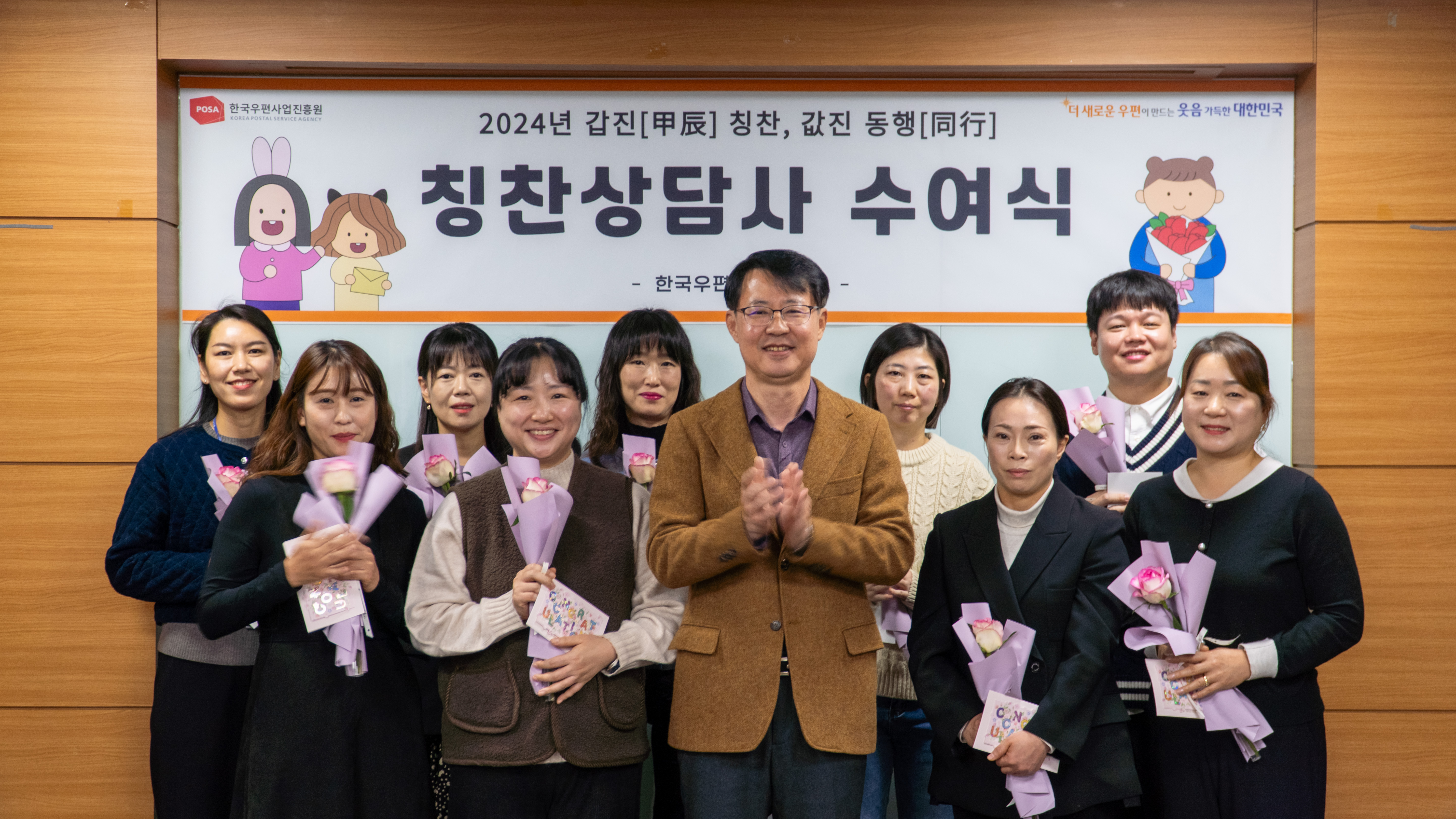 칭찬상담사 수여식 행사에서 꽃다발을 든 수상자들과 관계자가 함께 기념촬영하는 모습