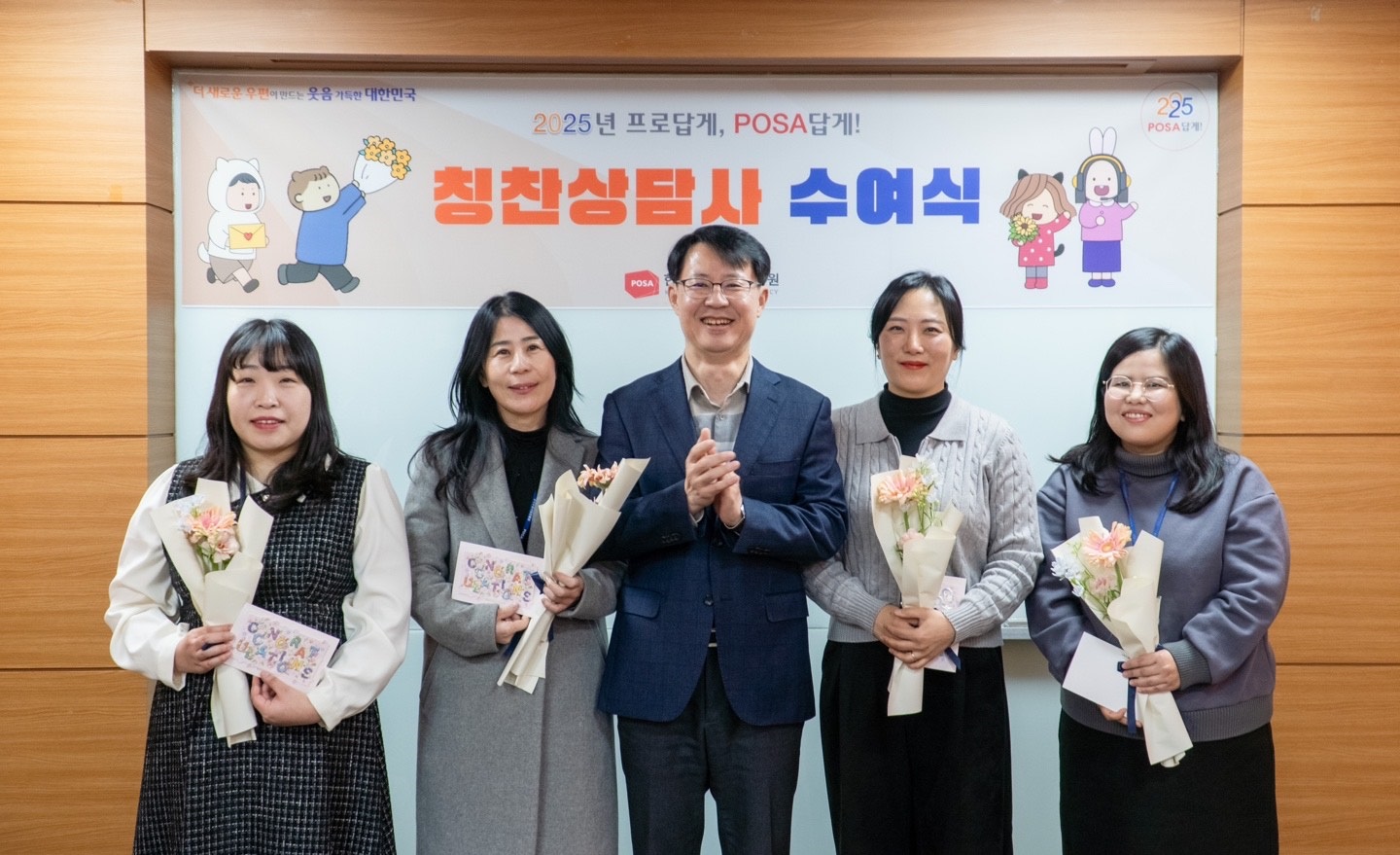 칭찬상담사로 선정된 직원 3명이 꽃다발과 편지를 들고 한국우편사업진흥원장과 함께 기념사진을 찍는 모습
