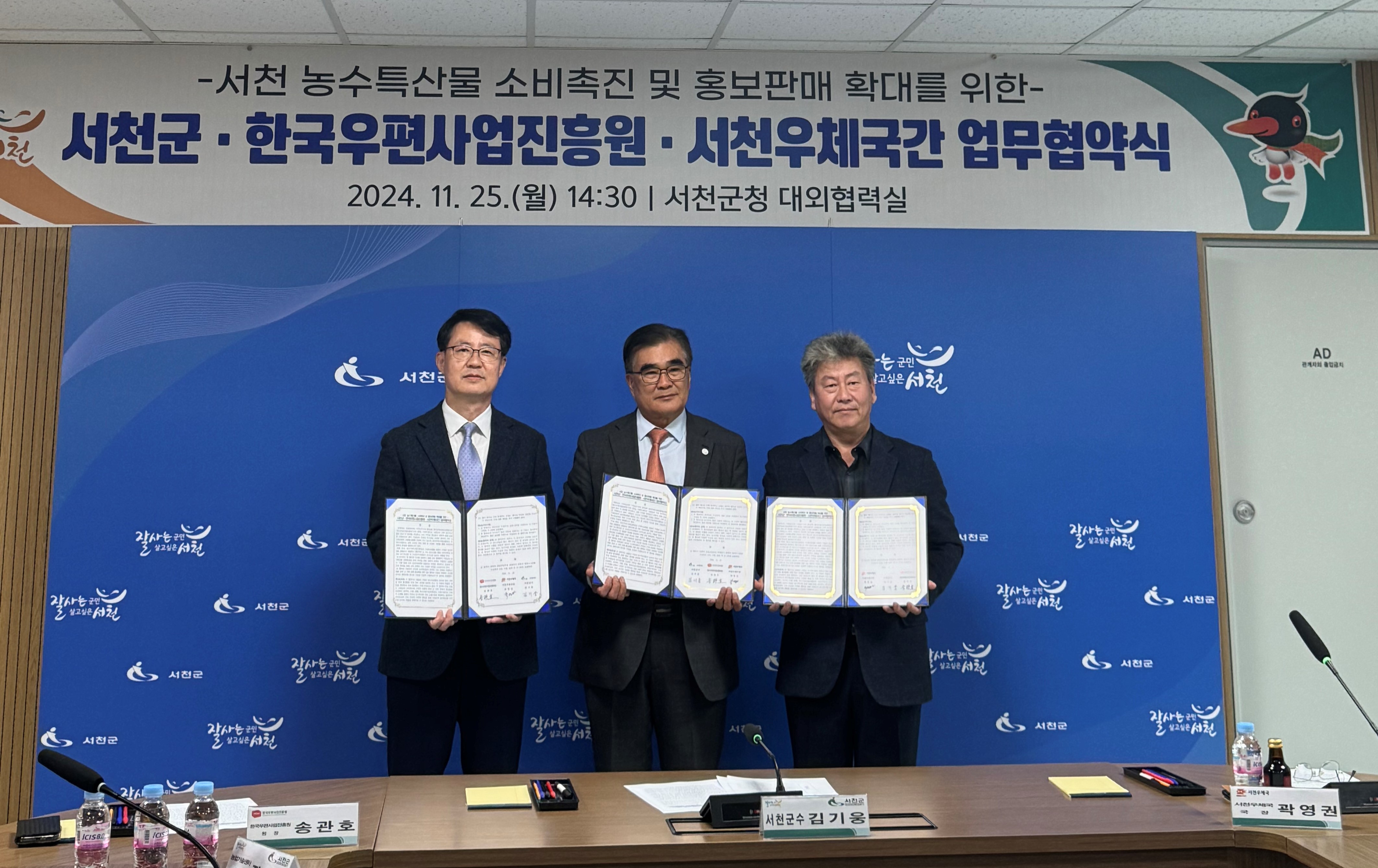 서천 농수특사문 소비촉진 및 홍보판매 확대 업무 협약서를 펼쳐들고 관계자들 기념촬영하는 모습