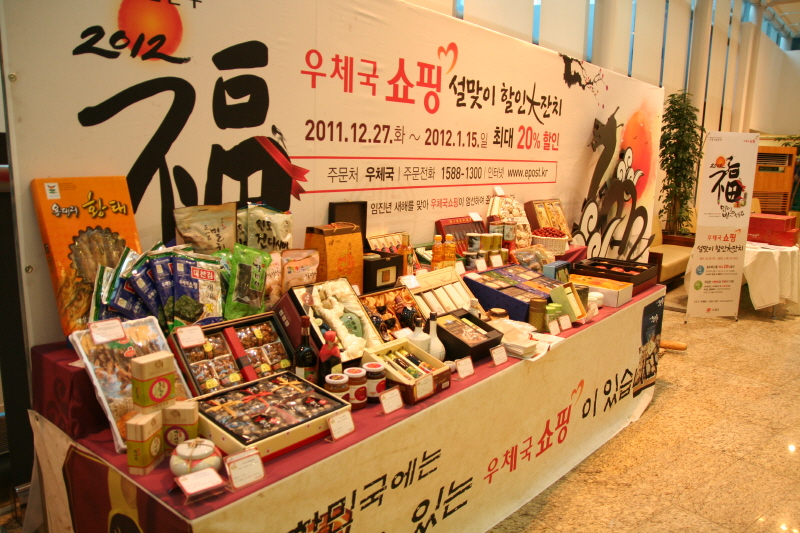 2012 우체국 쇼핑 설맞이 할인大잔치 / 2011.12.27.화 ~ 2012.1.15.일 최대 20% 할인 / 주문처 우체국 / 주문전화 1588-1300 / 인터넷 www.epost.kr / 설 할인행사로 진열된 상품들 사진이다.