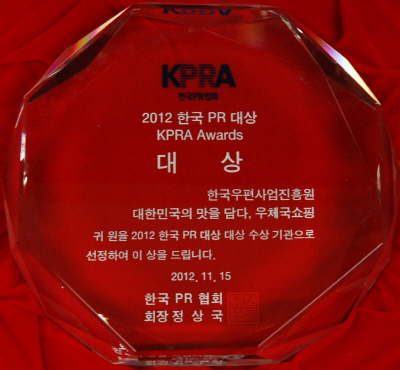 KPRA 한국PR협회 2012 한국 PR 대상 KPRA Awards 대상 한국우편사업진흥원 대한민국의 맛을 담다. 우체국쇼핑 귀 원을 2012 한국 PR 대상 대상 수상 기관으로 선정하여 이 상을 드립니다. 2012.11.15 한국 PR 협회 회장 정상국