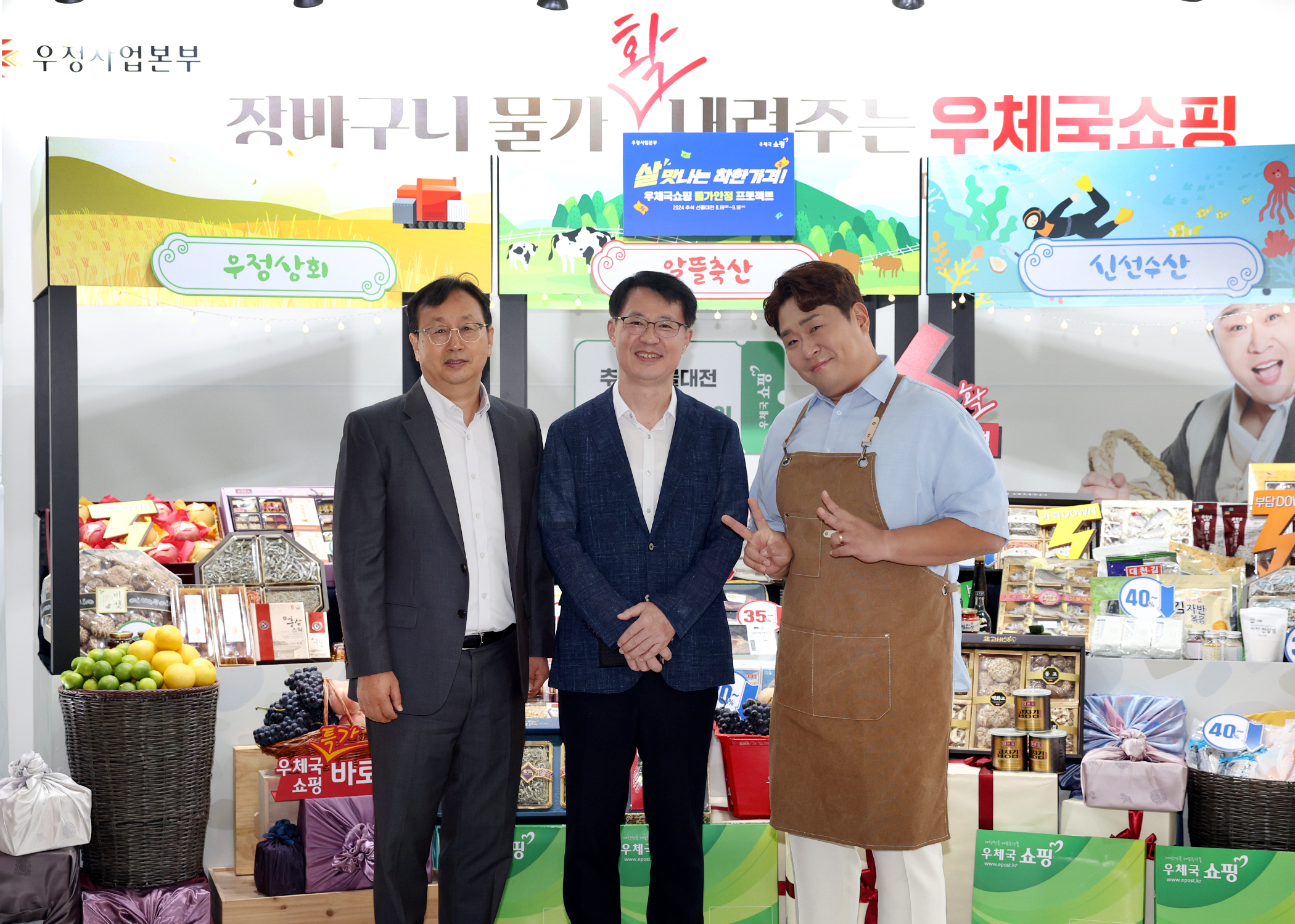 과일과 육류 등 다양한 특산물이 진열되어 있는 부스 앞에서 포즈를 취한 사진