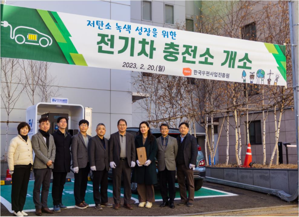 전기차 충전소 앞에서 단체로 사진을 찍는 모습