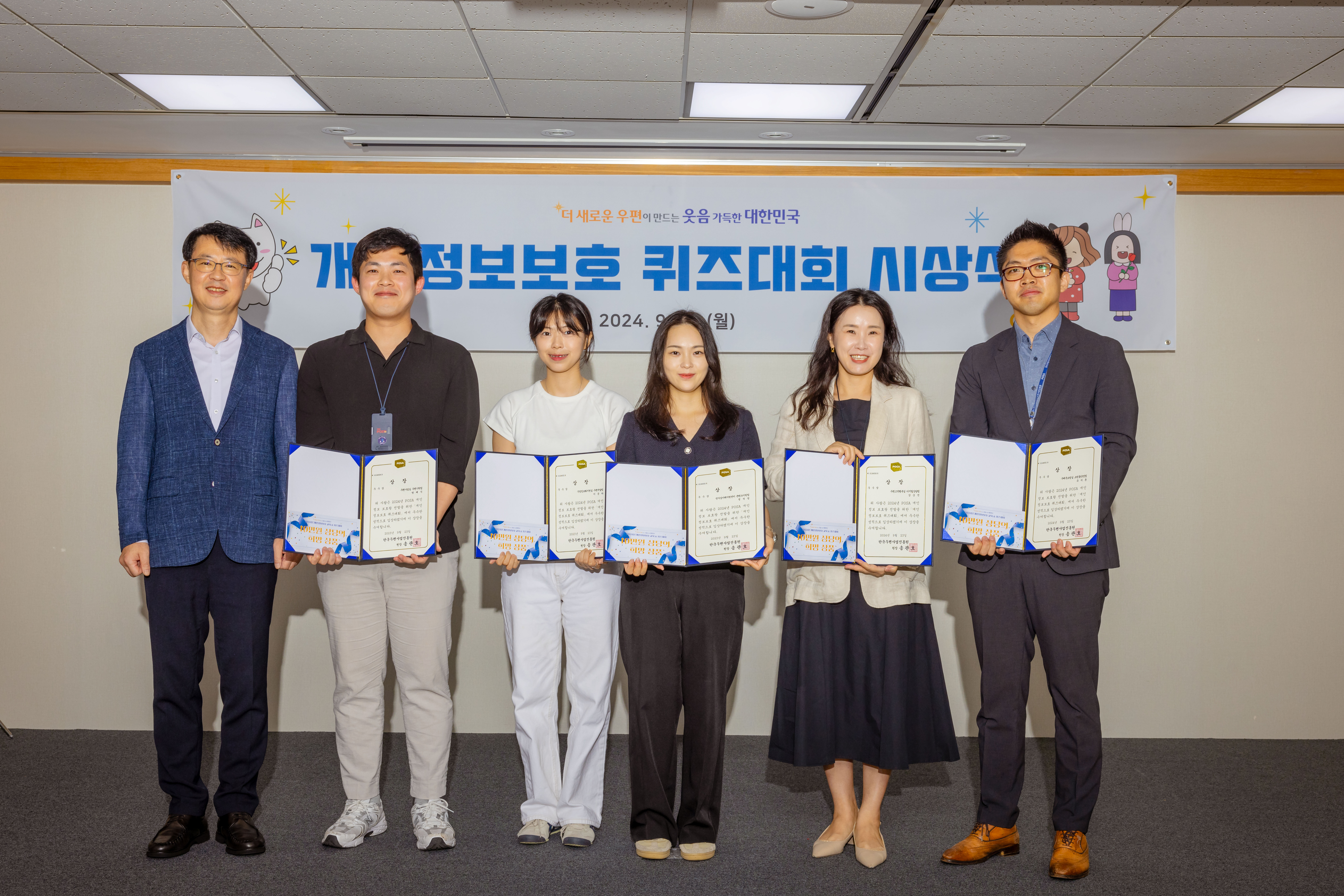 개인정보보호 퀴즈대회 수상 상장을 펼쳐서 기념촬영 중인 수상자 직원 사진