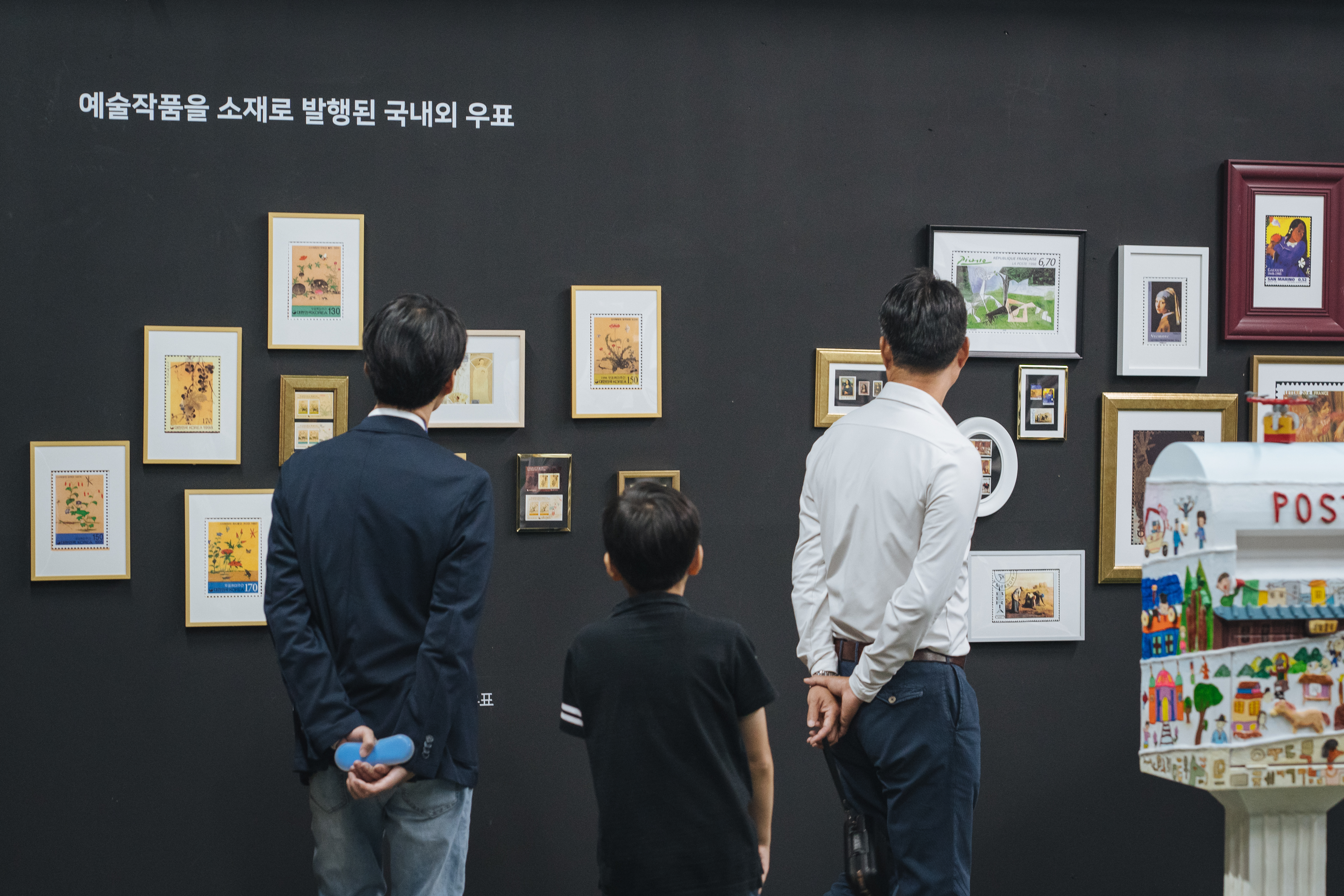 예술작품을 소재로 발행된 국내외 우표를 감상하고 있는 모습