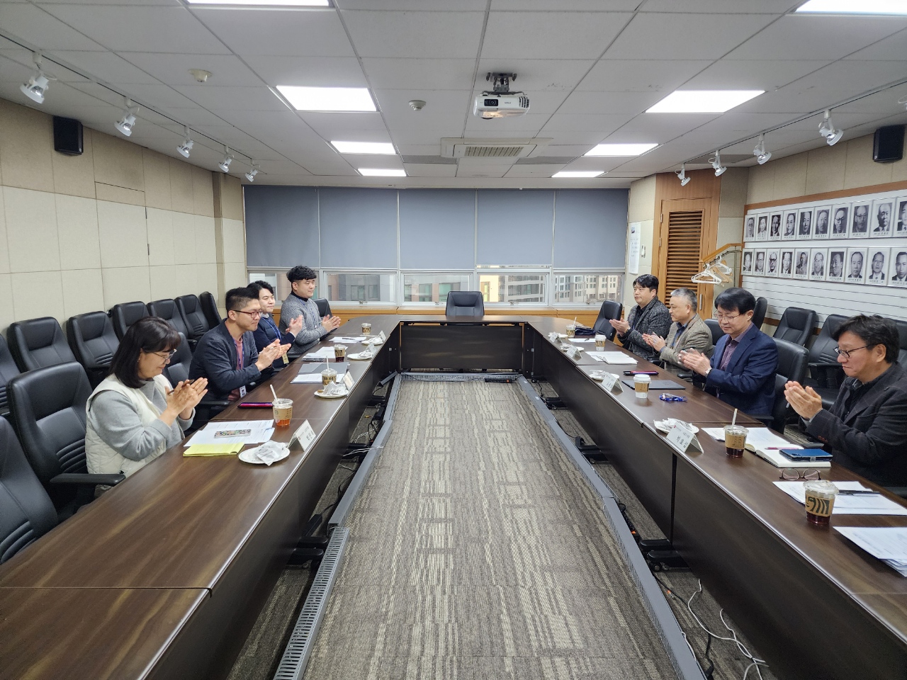 회의실에서 양측에 나란히 앉은 참석자들과 노사협의회를 진행하고 있는 모습