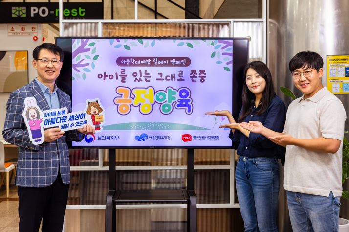 아동학대예방 릴레이’ 캠페인 홍보 화면 앞에서 세 명의 성인이 캠페인을 소개하며 포즈를 취하고 있는 모습