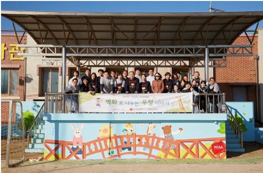 김포시 대곶면에 위치한 석정초등학교에서 사람들이 <벽화로 나누는 우정이야기> 현수막에서 촬영하는 모습
