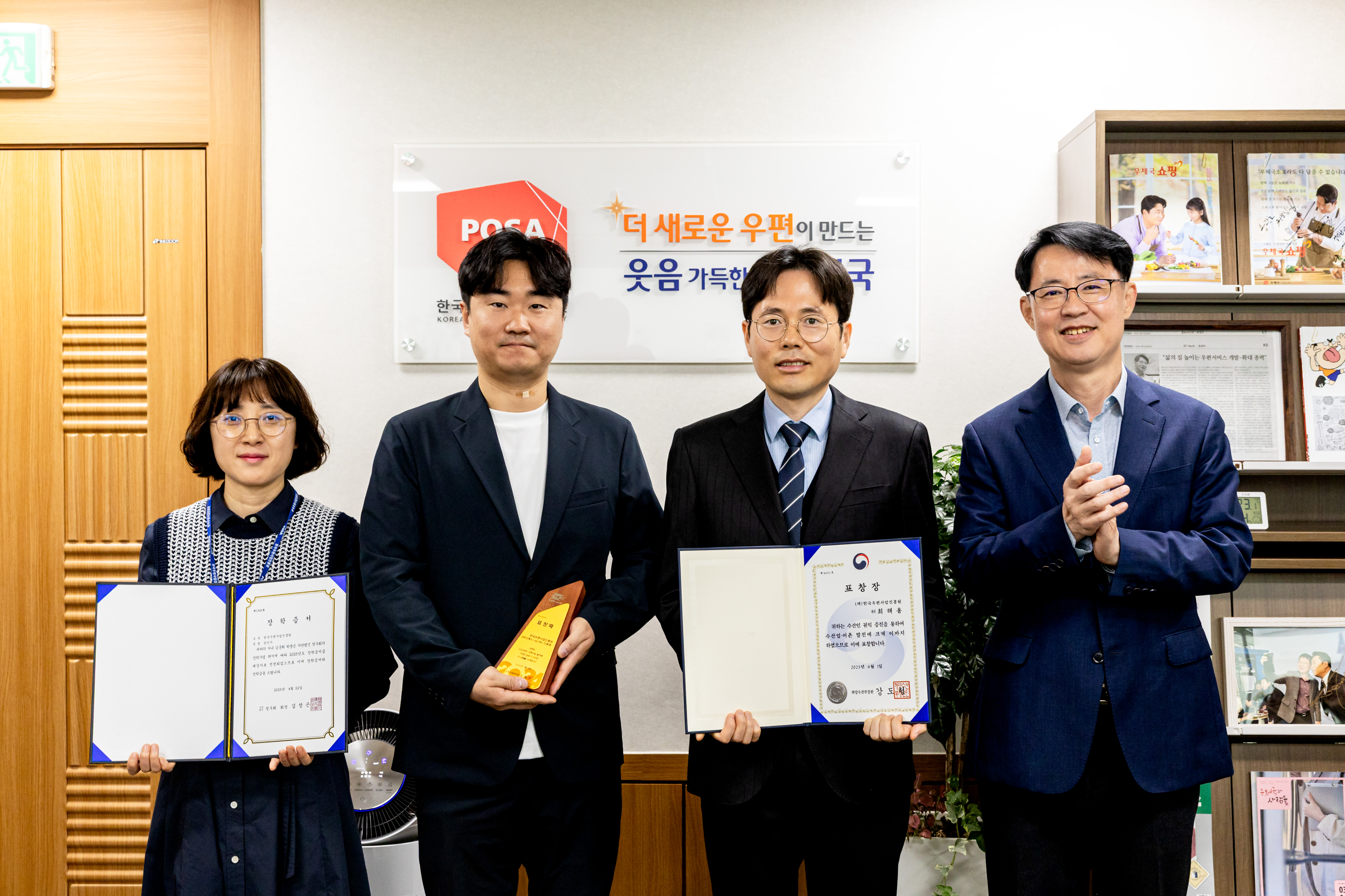외부포상 및 정우회 장학금 표창장을 펼치고 있는 수여자 3명과 한국우편사업진흥원장이 함께 기념촬영을 하는 모습