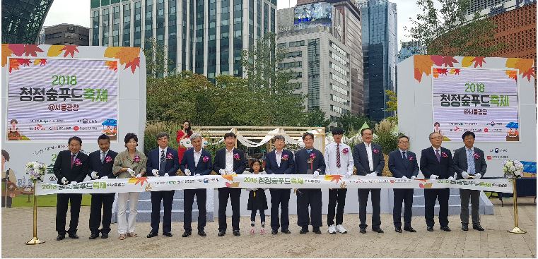 서울광장에서 열리는 '2018 청정숲푸드 축제 개막식 행사'에 참석하여 테이프 커팅식을 준비하고 있는 사람들