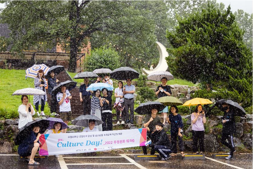 우산을 쓰고 단체로 사진을 찍는 모습