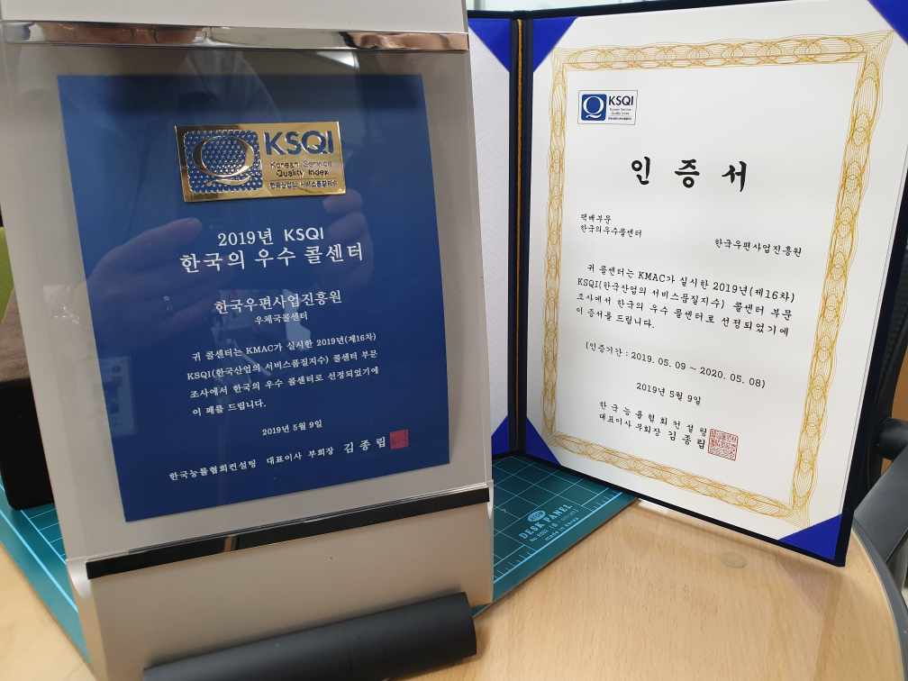 2019년 KSQI 한국의 우수 콜센터 인증상패, 인증서(KSQI/2019년 KSQI 한국의 우수 콜센터/한국우편사업진흥원 우체국콜센터/귀 콜센터는 KMAC가 실시한 2019년(제16차) KSQI(한국산업의 서비스품질지수) 콜센터 부문 조사에서 한국의 우수 콜센터로 선정되었기에 이 패를 드립니다/2019년 5월 9일/ 한국능률협회컨설팅 대표이사 부회장 김종립)